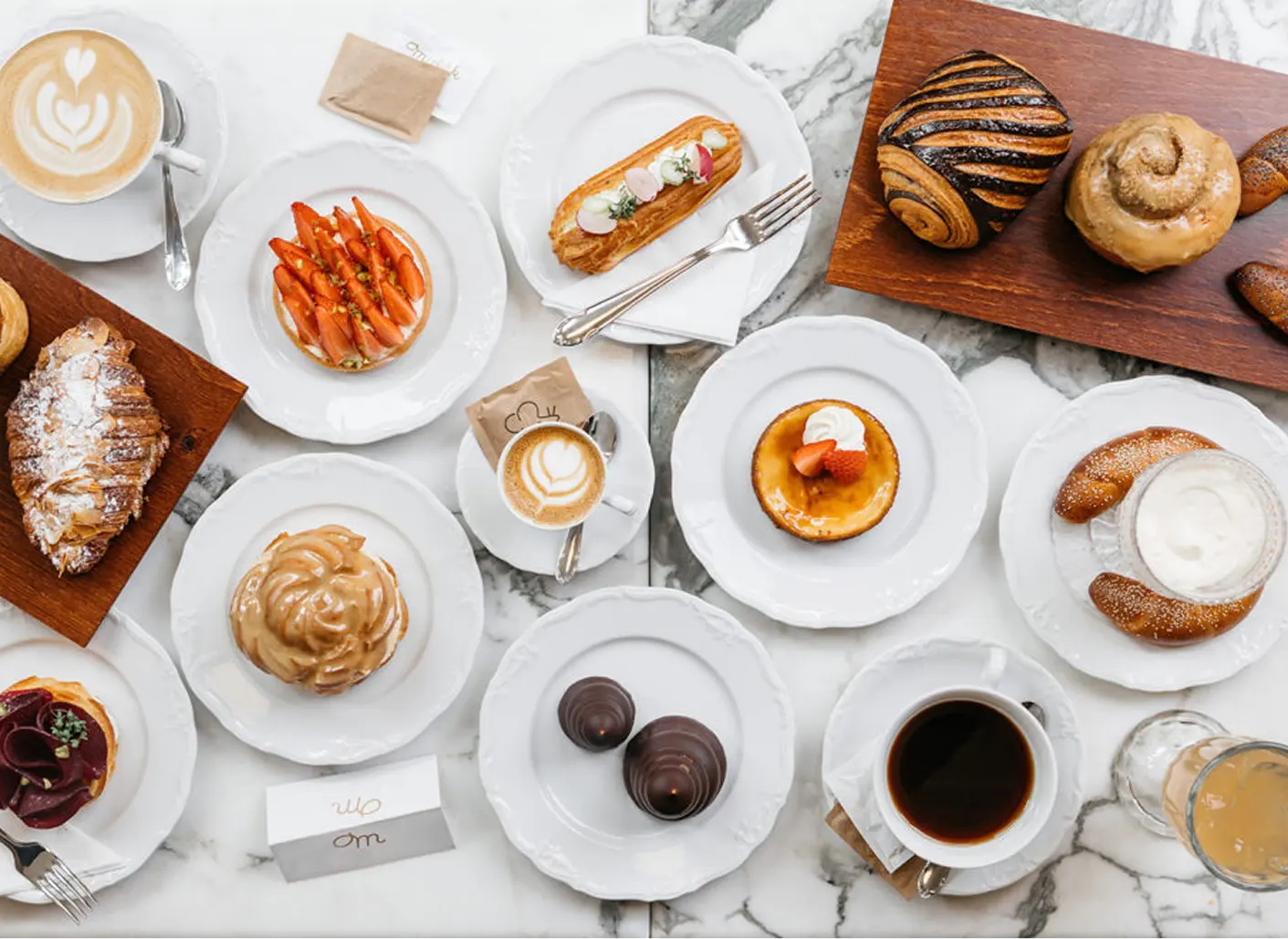 Selection of desserts and coffee served on a marble table.