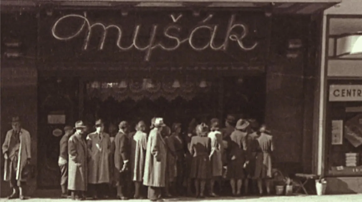 Historic photo of customers queuing outside Myšák patisserie.