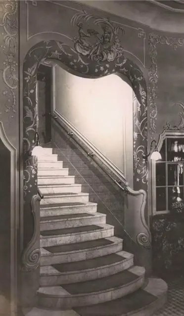 Historic staircase inside Myšák pastry shop with decorative archway.